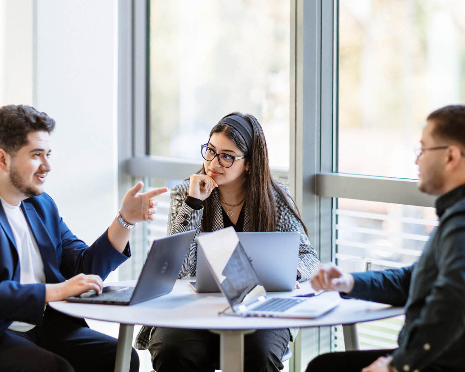 trois étudiants en discussion autour d'une table